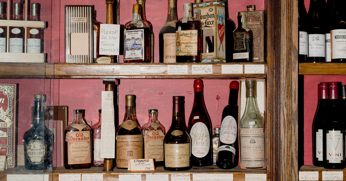 A curated collection of rare and vintage spirits — amaro and aged bottles arranged on a bar shelf